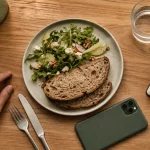 Manger en pleine conscience : table, assiette et eau, main avant le repas